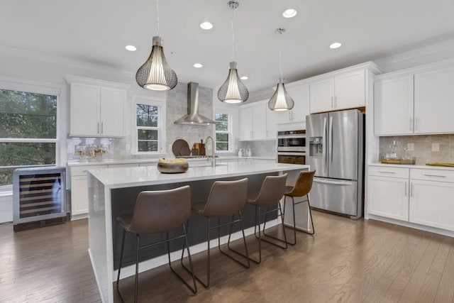 kitchen featuring white cabinets, stainless steel fridge with ice dispenser, decorative backsplash, beverage cooler, and wall chimney exhaust hood