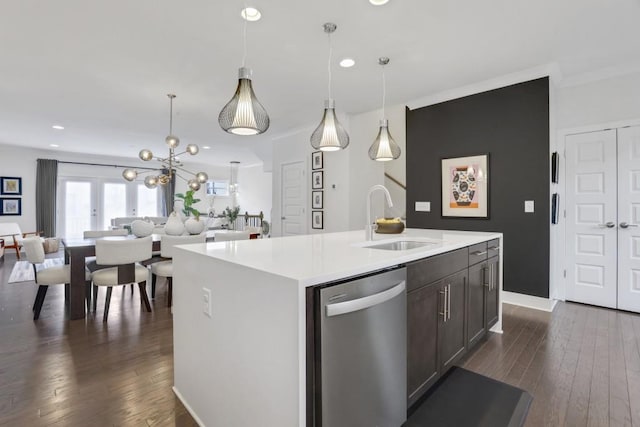 kitchen with pendant lighting, an island with sink, sink, stainless steel dishwasher, and dark wood-type flooring