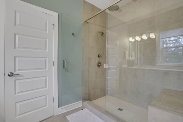 bathroom with a shower with shower door and tile patterned flooring