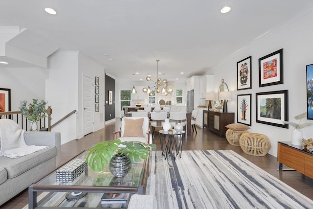 living room featuring a notable chandelier, crown molding, and dark hardwood / wood-style floors