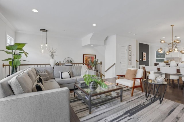 living room featuring ornamental molding, hardwood / wood-style floors, and an inviting chandelier