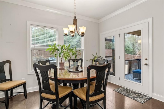 dining space featuring ornamental molding, dark hardwood / wood-style floors, and an inviting chandelier