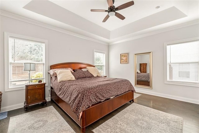 bedroom featuring ceiling fan, dark hardwood / wood-style flooring, and a raised ceiling