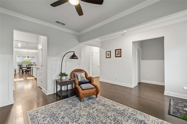 living area with crown molding, ceiling fan, and dark hardwood / wood-style flooring