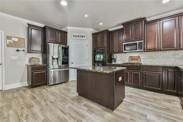 3060 Mccannon Mill Dr, Dacula, GA 30019 - kitchen with stainless steel appliances, crown molding, dark stone countertops, a kitchen island, and recessed lighting