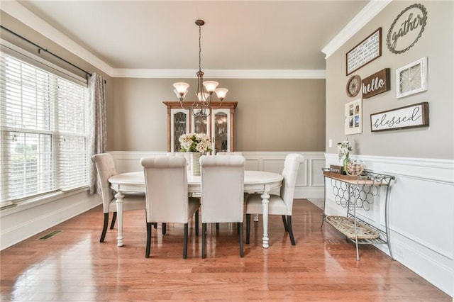 3060 Mccannon Mill Dr, Dacula, GA 30019 - dining area featuring a chandelier, ornamental molding, a wainscoted wall, wood finished floors, and a decorative wall