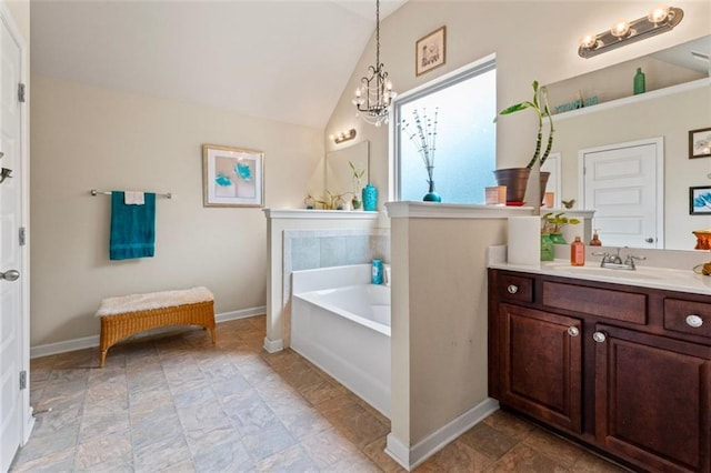 bathroom with vanity, a tub, a chandelier, and vaulted ceiling