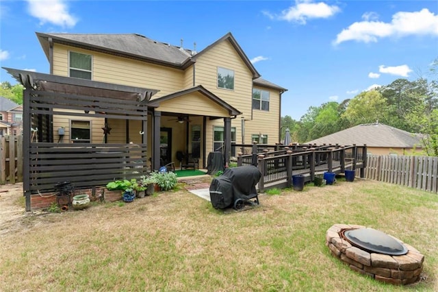 back of house with a fire pit, a yard, and a pergola