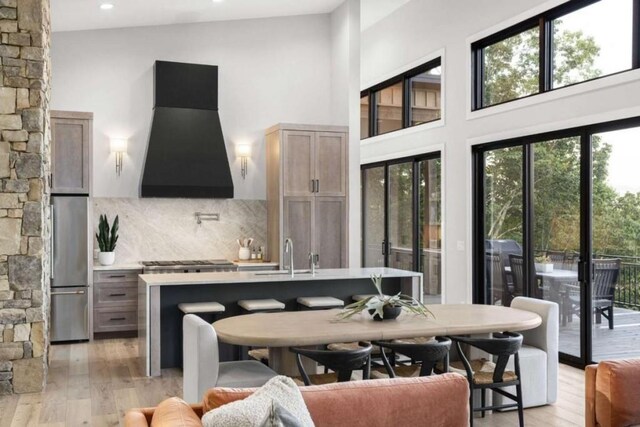 interior space featuring a high ceiling, sink, and light hardwood / wood-style floors