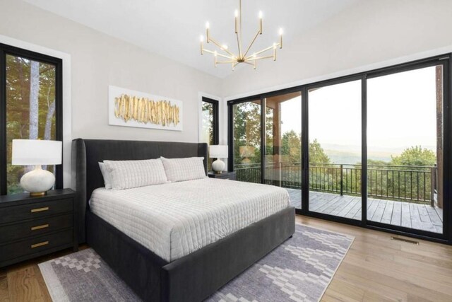 bedroom with a chandelier, light hardwood / wood-style floors, and access to outside