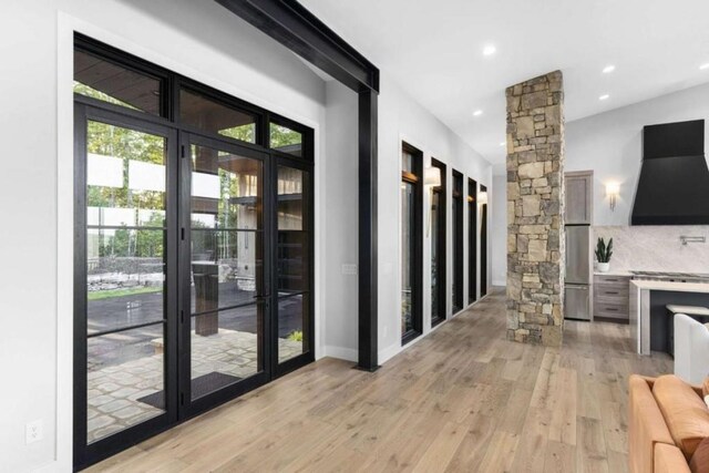 entryway featuring ornate columns and light hardwood / wood-style flooring