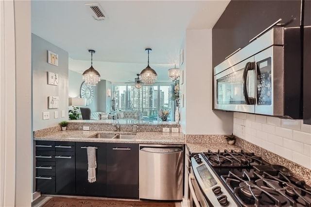 3338 Peachtree Rd NE Unit 1507, Atlanta, GA 30326 - kitchen featuring appliances with stainless steel finishes, decorative light fixtures, light stone counters, ceiling fan, and decorative backsplash