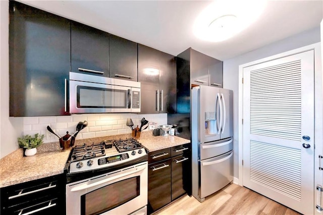 3338 Peachtree Rd NE Unit 1507, Atlanta, GA 30326 - kitchen with appliances with stainless steel finishes, light wood-style floors, and decorative backsplash