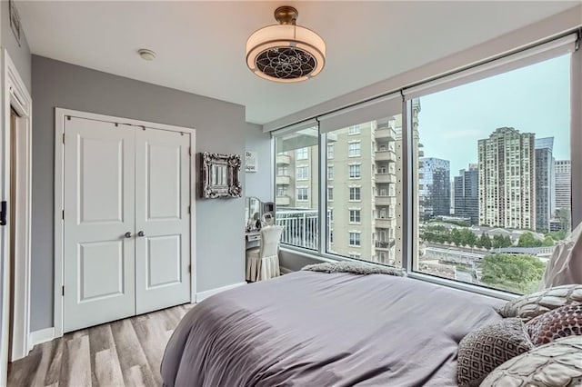 3338 Peachtree Rd NE Unit 1507, Atlanta, GA 30326 - bedroom featuring wood finished floors, a closet, and a city view