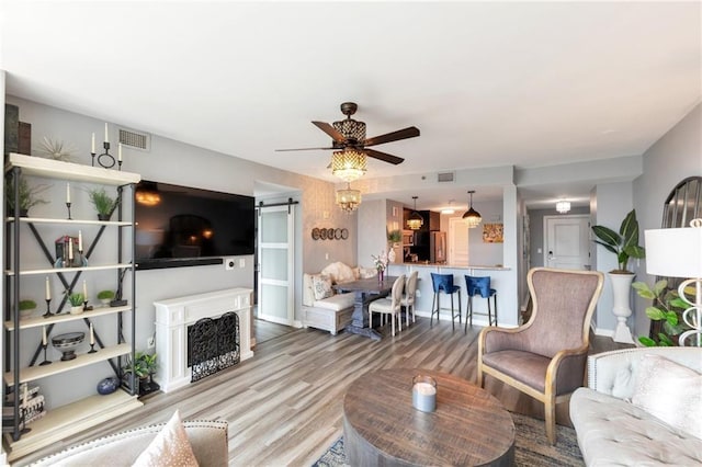 3338 Peachtree Rd NE Unit 1507, Atlanta, GA 30326 - living area featuring a ceiling fan, a barn door, wood finished floors, and a fireplace