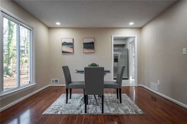 dining area with plenty of natural light and dark hardwood / wood-style flooring