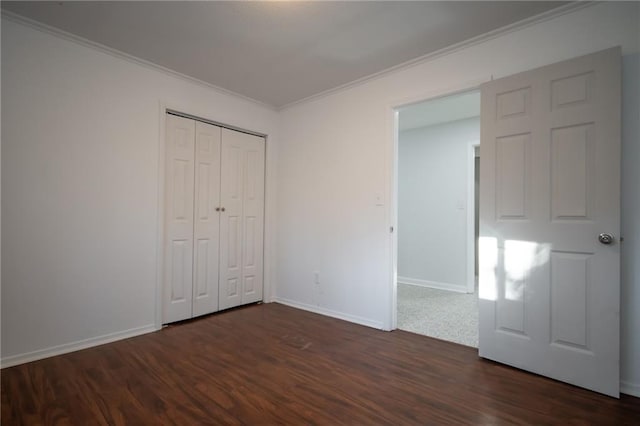 unfurnished bedroom featuring crown molding, dark wood-type flooring, and a closet