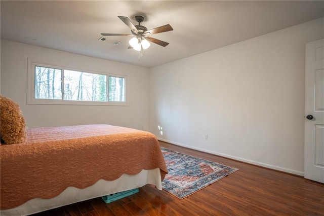 bedroom with dark hardwood / wood-style floors and ceiling fan