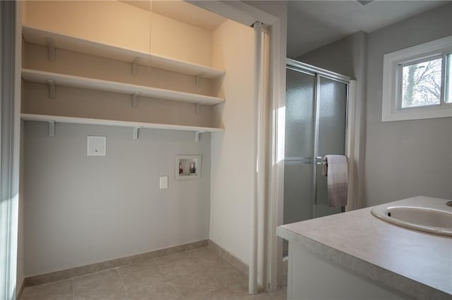 washroom featuring sink, hookup for a washing machine, and light tile patterned floors