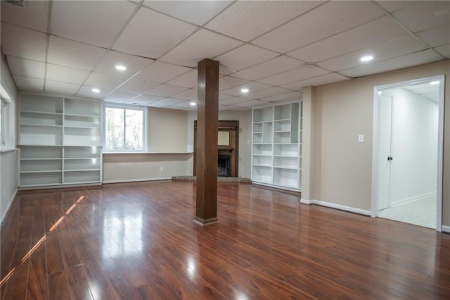 basement featuring built in features and dark hardwood / wood-style flooring