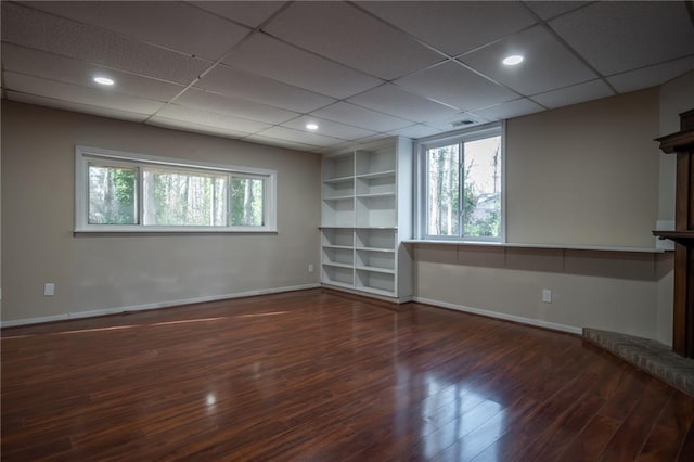 interior space featuring dark hardwood / wood-style flooring, plenty of natural light, and a paneled ceiling