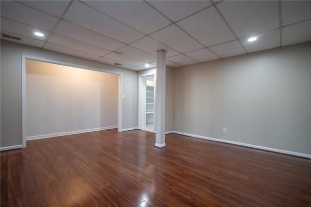 interior space featuring a drop ceiling and dark hardwood / wood-style flooring