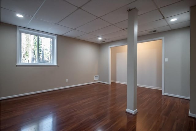 basement featuring dark hardwood / wood-style flooring and a paneled ceiling