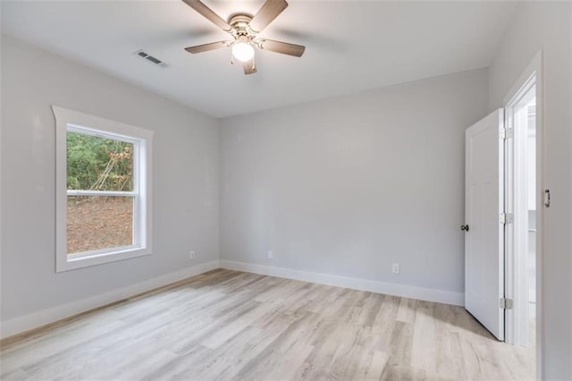 empty room with light wood-style floors, baseboards, visible vents, and a ceiling fan