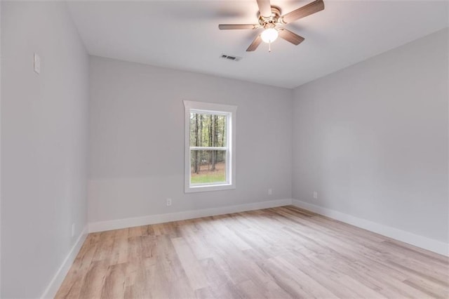 spare room with ceiling fan, wood finished floors, visible vents, and baseboards