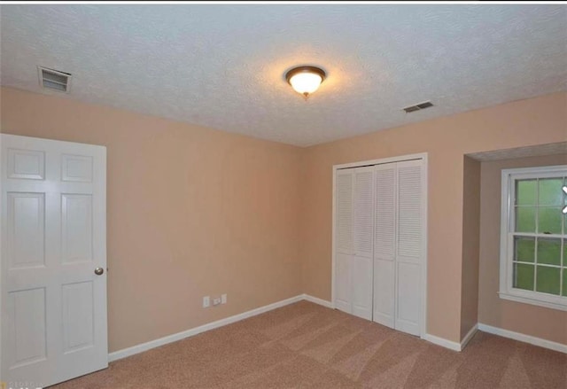 unfurnished bedroom featuring a closet, carpet flooring, visible vents, and baseboards