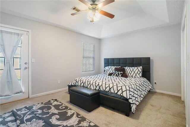 bedroom featuring light carpet, a raised ceiling, and ceiling fan