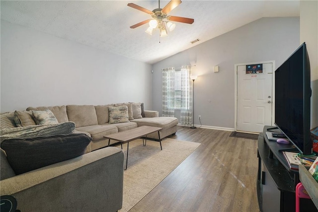 living room with hardwood / wood-style floors, ceiling fan, a textured ceiling, and vaulted ceiling