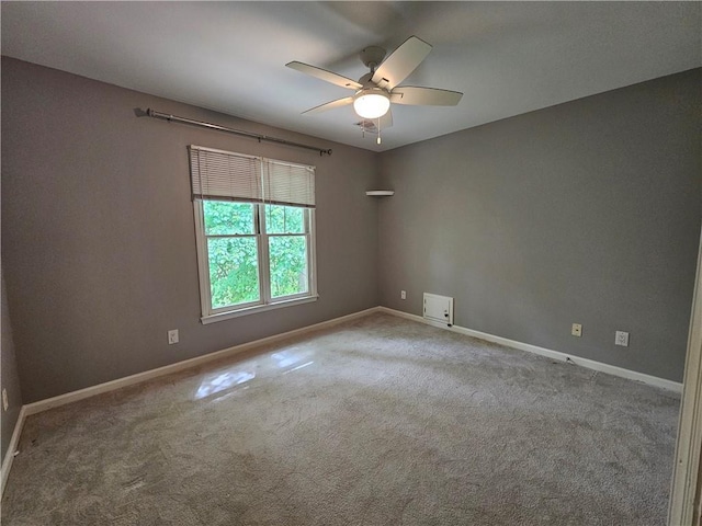 empty room featuring baseboards, a ceiling fan, and carpet