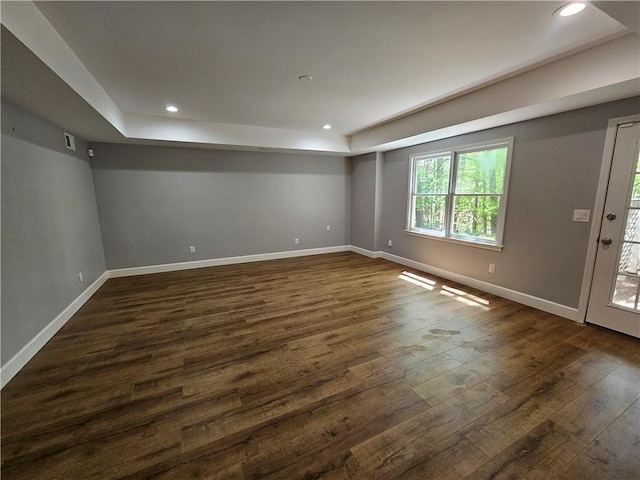 interior space featuring baseboards, dark wood-style floors, recessed lighting, and a tray ceiling
