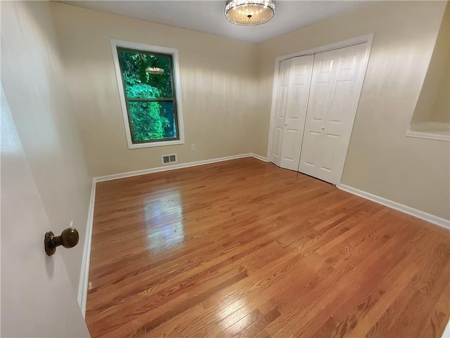 unfurnished bedroom featuring light hardwood / wood-style floors and a closet