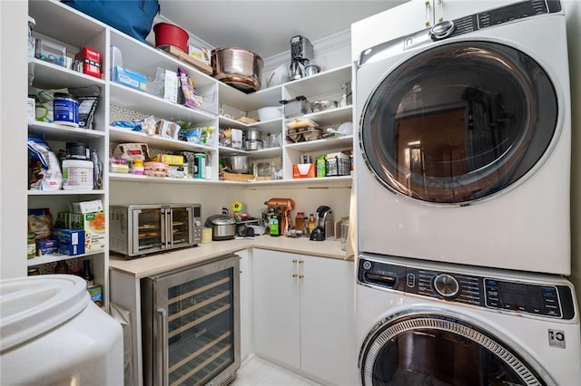 laundry room featuring wine cooler, laundry area, and stacked washer / dryer