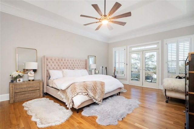 bedroom with access to outside, multiple windows, ornamental molding, and wood finished floors