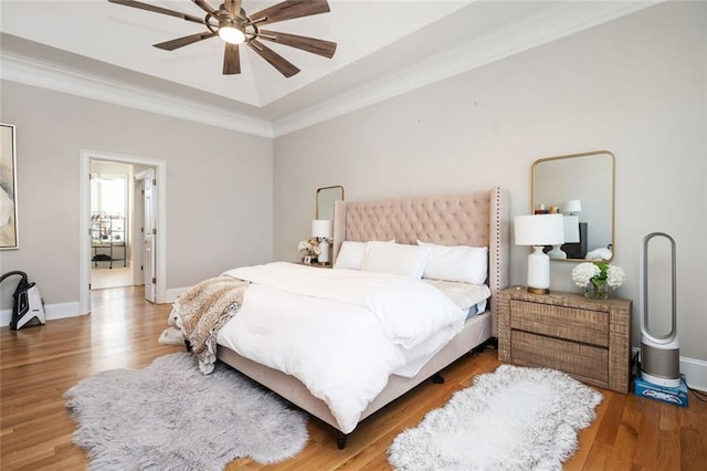 bedroom featuring ornamental molding, wood finished floors, a ceiling fan, and baseboards