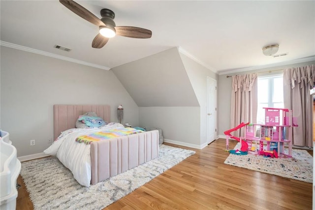 bedroom with baseboards, crown molding, visible vents, and wood finished floors