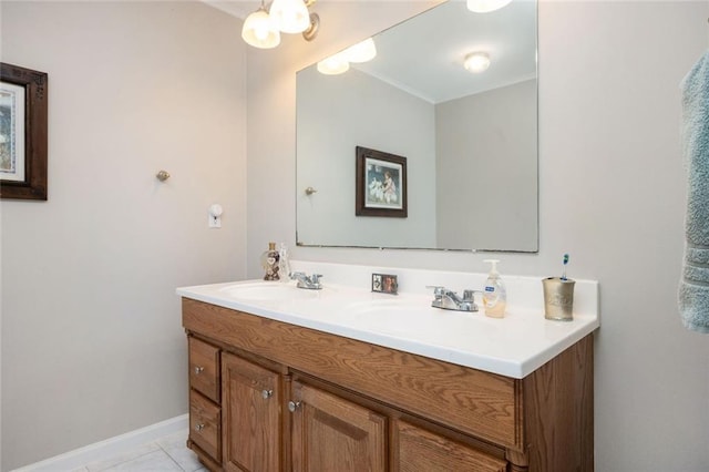 bathroom with baseboards, double vanity, a sink, and tile patterned floors