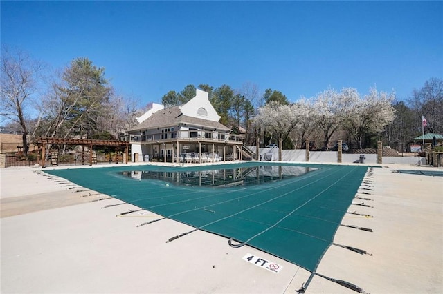 community pool with a patio and fence