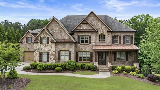 view of front facade with a standing seam roof, a front lawn, metal roof, and brick siding
