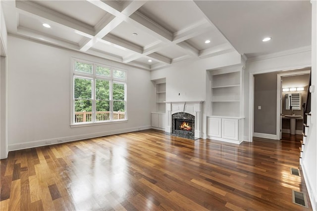 unfurnished living room featuring wood finished floors, baseboards, built in features, recessed lighting, and beamed ceiling