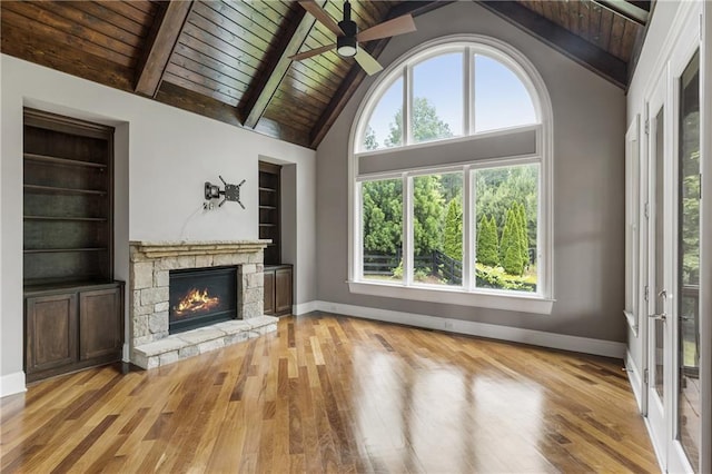 unfurnished living room with wood ceiling, a ceiling fan, light wood-style flooring, baseboards, and built in shelves