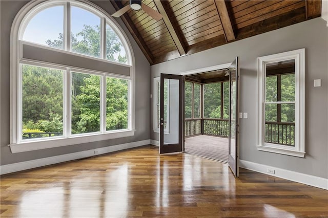 foyer with wooden ceiling, plenty of natural light, baseboards, wood finished floors, and beam ceiling