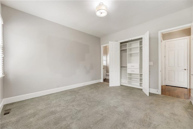 unfurnished bedroom with carpet floors, baseboards, and a closet