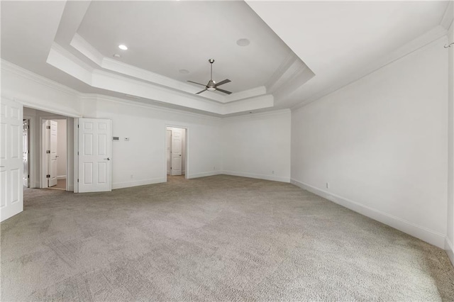 unfurnished bedroom with ornamental molding, a raised ceiling, light colored carpet, baseboards, and recessed lighting