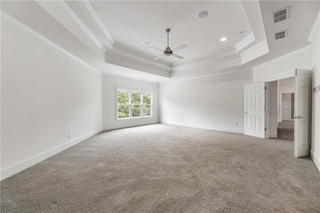 empty room featuring ceiling fan, a tray ceiling, crown molding, carpet floors, and baseboards