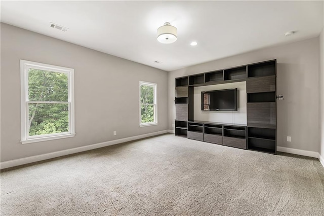 unfurnished living room featuring baseboards and carpet