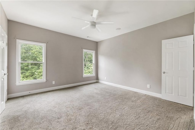 spare room featuring ceiling fan, carpet, and baseboards